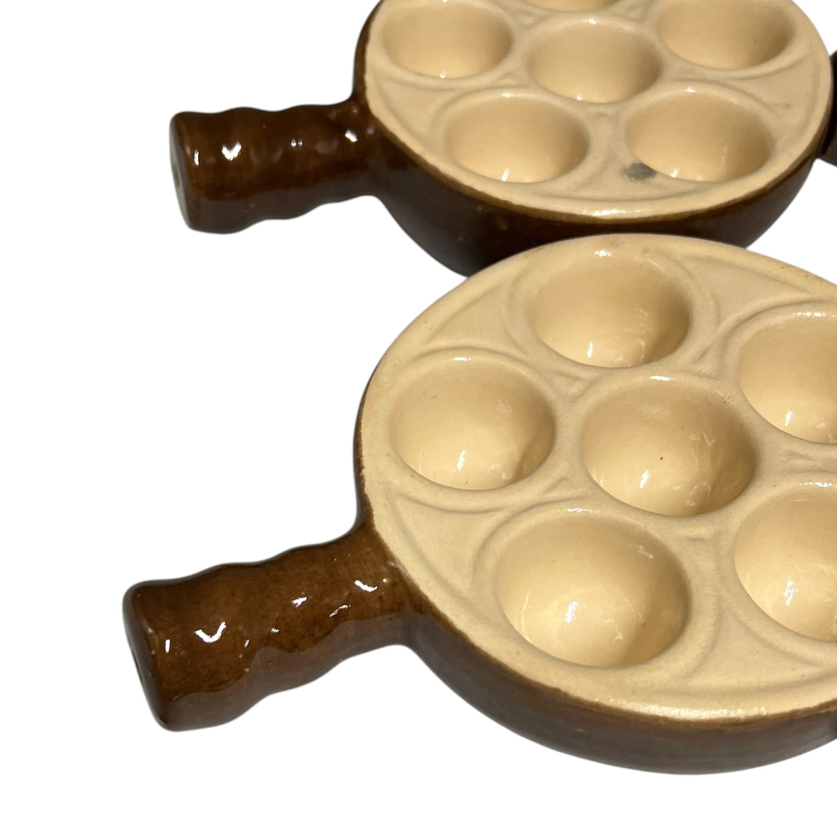 Two ceramic snail plates with brown handles and beige-brown recessed cavities, shown on a plain white background.