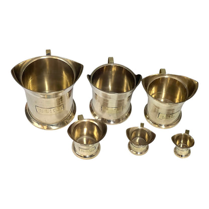 Set of brass measuring cups on a white background