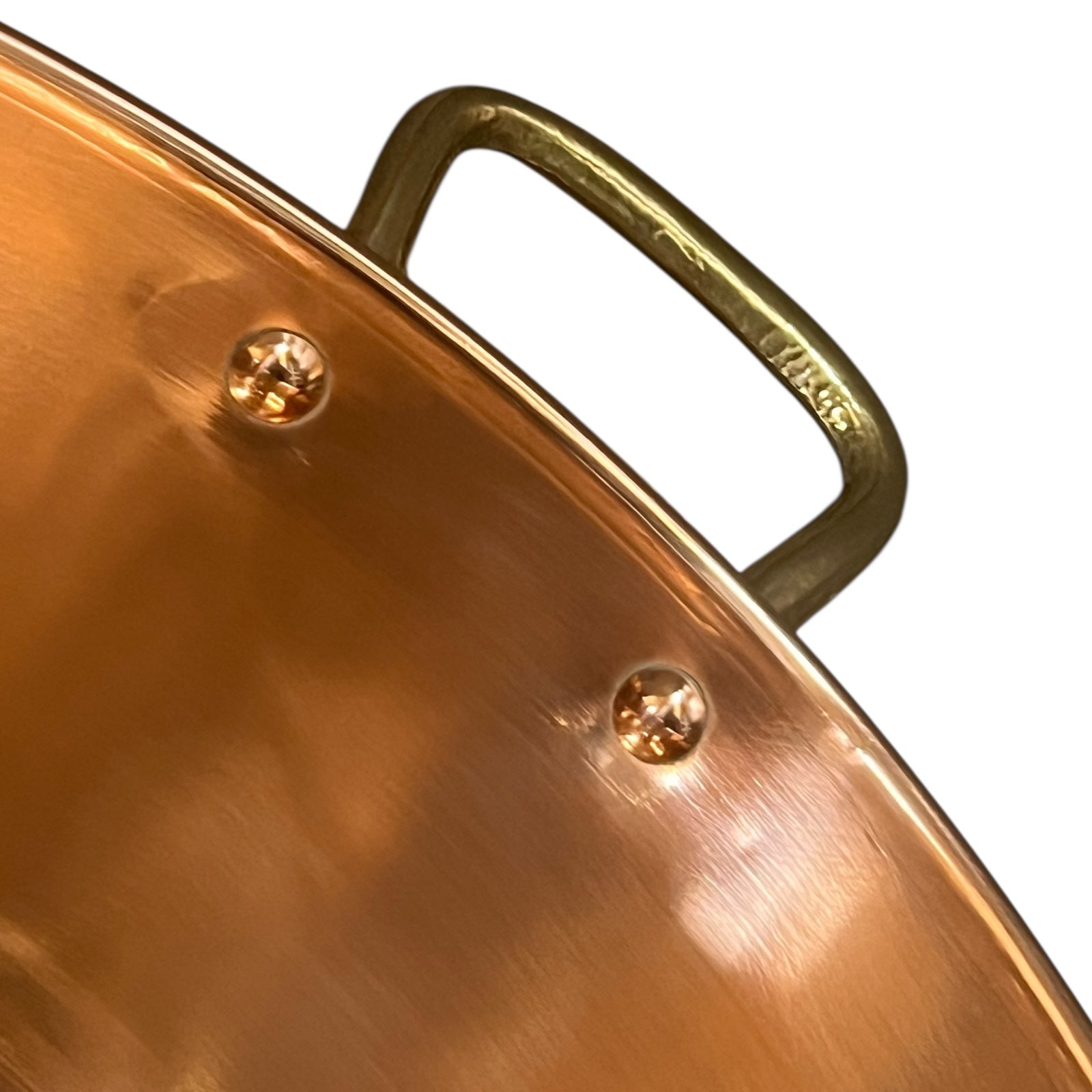 Close-up of a copper sink with a brass handle on a white background