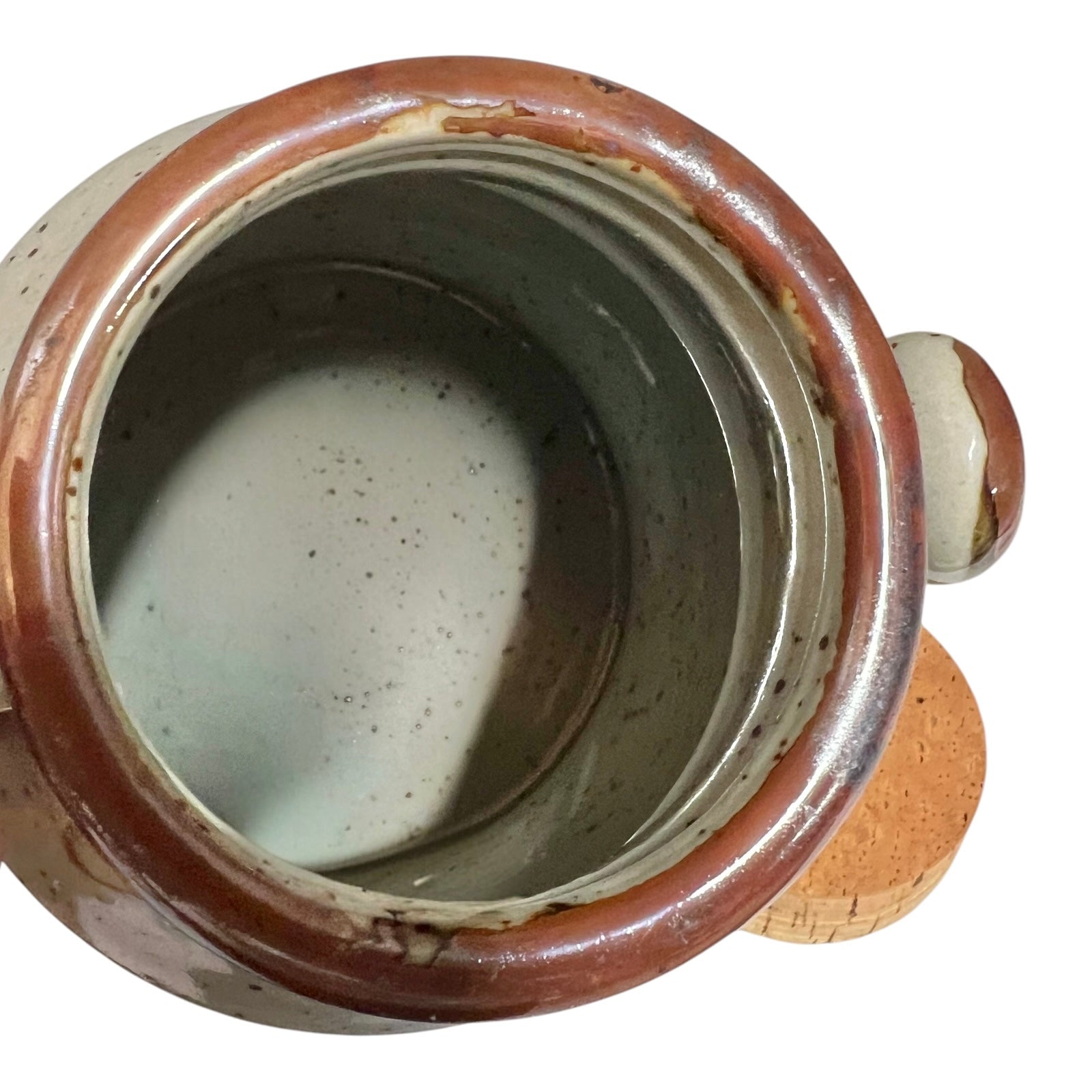 Close-up of a ceramic pot with a brown rim on a white background