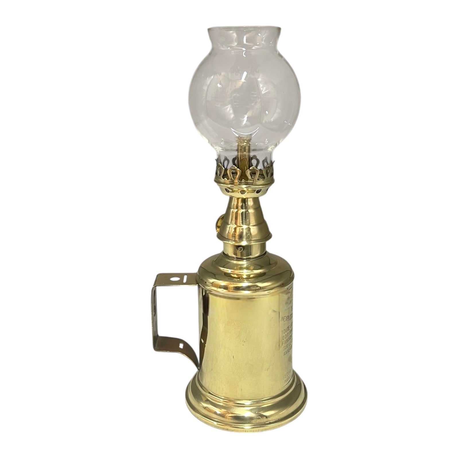 Brass oil lamp with clear glass shade on a white background