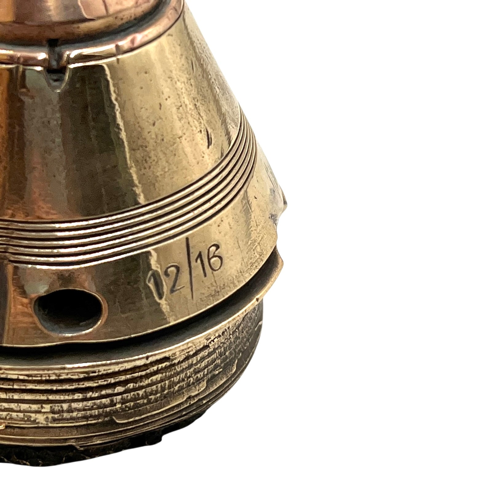 Close up of a polished British brass WW1 fuse or paperweight type 101 on a white background