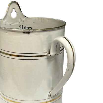 A vintage white enamel or painted metal bucket with a handle, a hanging loop on the rim, and thin gold stripes, shown on a white background.