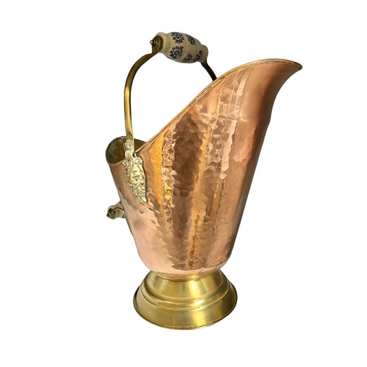 Copper and brass French vintage coal bucket with decorative ceramic handles on a white background