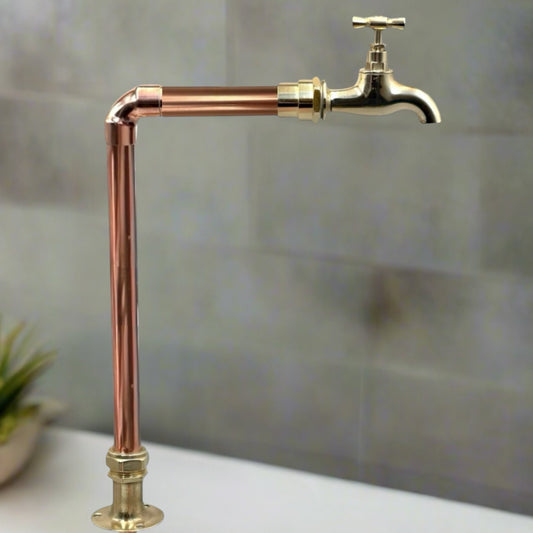 Vintage-style copper and brass tap faucet against a neutral background