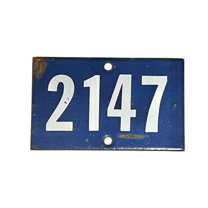 Blue and white enamel door number 2147 on a white background 