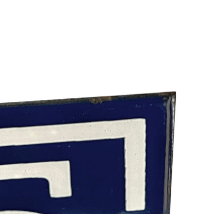 Close up of blue and white door number 65 on a white background 