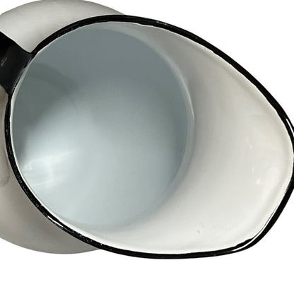 Close-up of a white jug with black rim on a white background