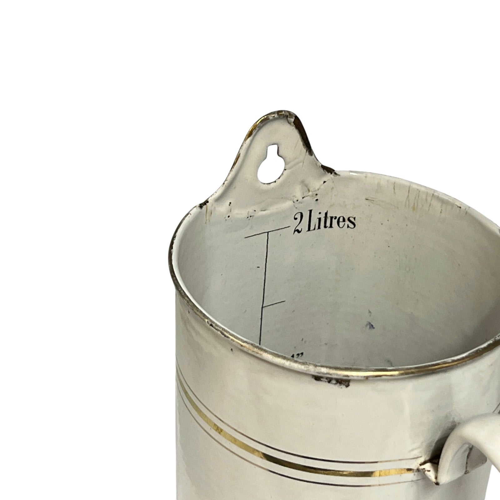 A close-up of a vintage metal measuring jug with a 2 litres capacity, featuring a hanging loop at the rim and measurement markings inside.