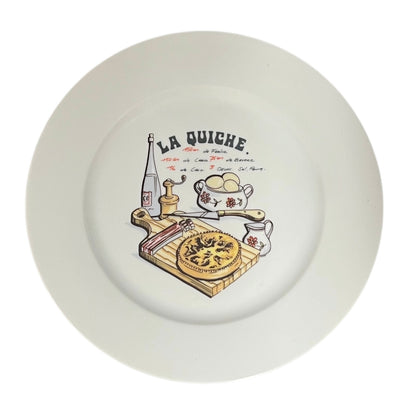White plate with a decorative design of a pie, cutting board, and text 'La Quiche' on a white background.