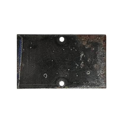 A rectangular black metal plate with two pre-drilled holes, showing signs of rust, wear, and scratches, isolated on a white background.