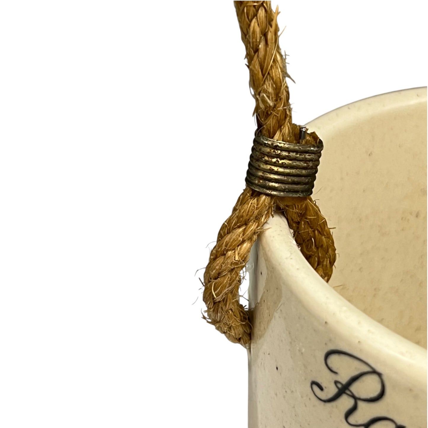 Close-up of a cream-coloured ceramic planter with a thick natural jute rope handle wrapped in a textured bronze metal band, shown against a plain white background.