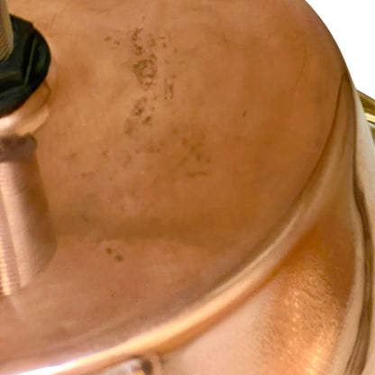 Close-up of a copper sink with a drain plug
