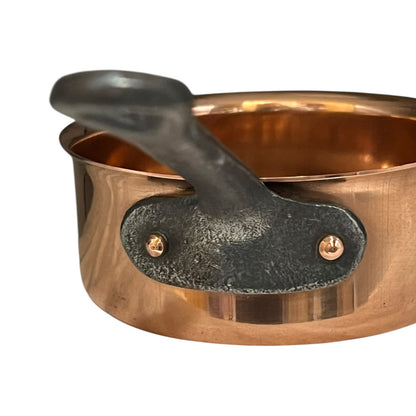 Copper pot with a black handle on a white background