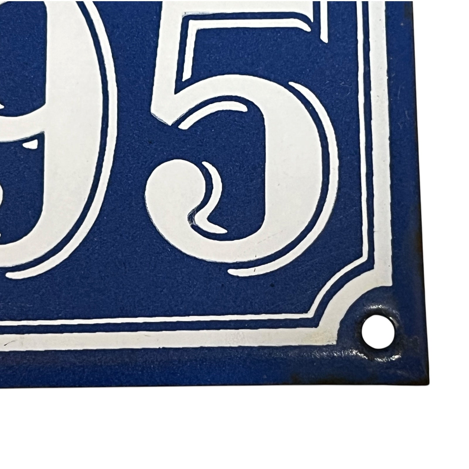 Blue and white house number '95' sign with a hole for hanging.