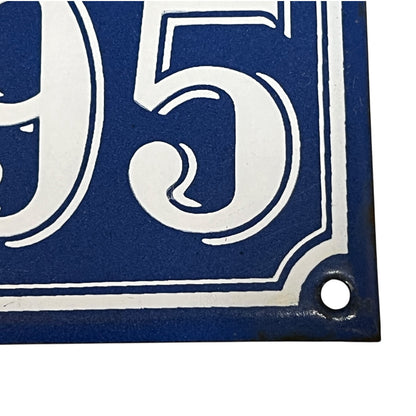 Blue and white house number '95' sign with a hole for hanging.