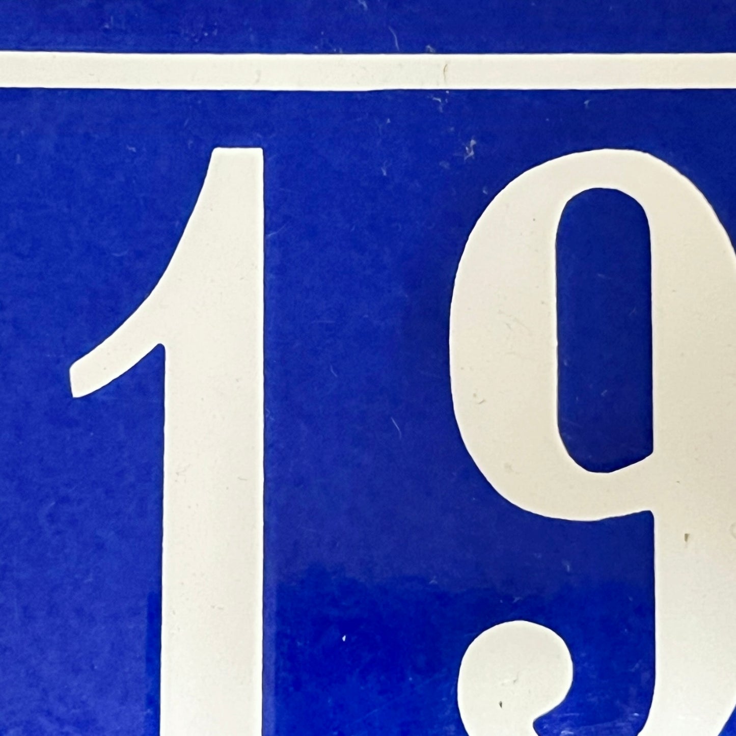 Close-up of a blue sign with white numbers '19'.