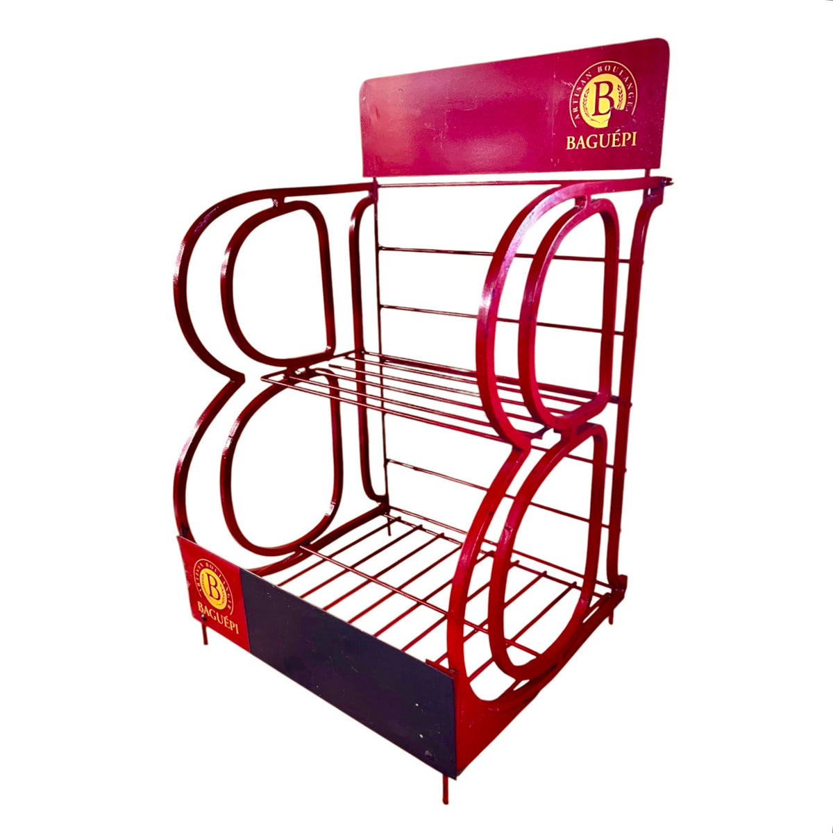 A red metal retail display rack with three tiers, featuring a decorative arch design and 'BAGUÉPI' branding on the top panel and base.