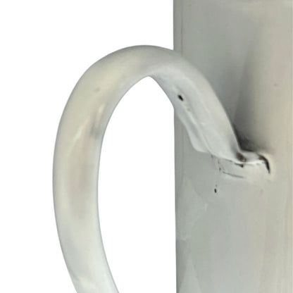 Close up of  French vintage enamel planter with a flat back and a spout on a white background