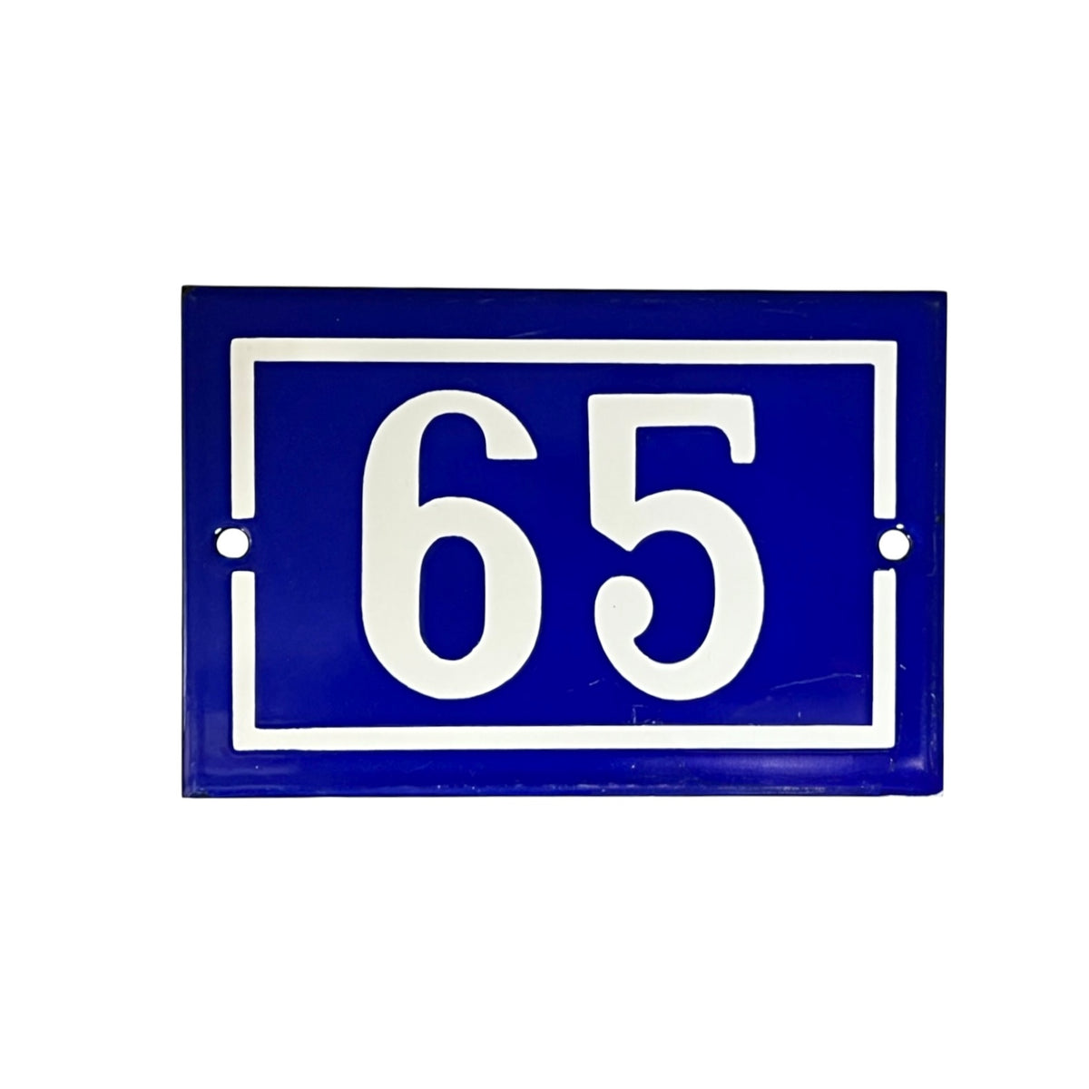 A rectangular blue house number plaque with white lettering reading '65' inside a white border, shown on a plain white background.