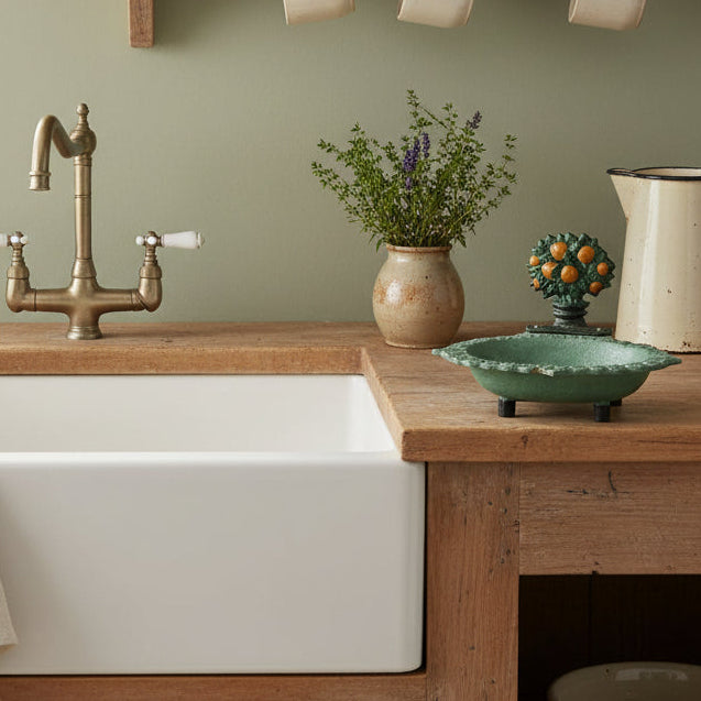 Decorative soap dish with a greenish patina on a counter in a Farmhouse kitchen