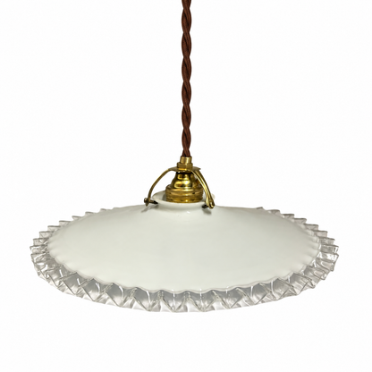 A vintage-style pendant light with a white scalloped glass shade, a brass metal fixture, and a brown twisted cord, shown against a plain white background.