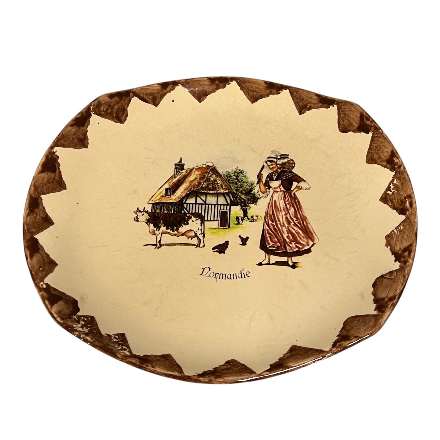 Decorative plate with a rural scene and 'Normandie' text on a white background