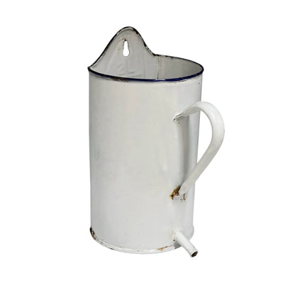 A vintage white enamel pitcher planter jug with a blue rim, featuring a handle, pouring spout, and top carrying loop, shown against a plain white background.