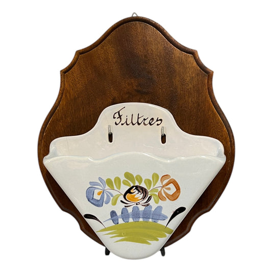 Decorative ceramic coffee filter paper with floral design and wooden back on a white background