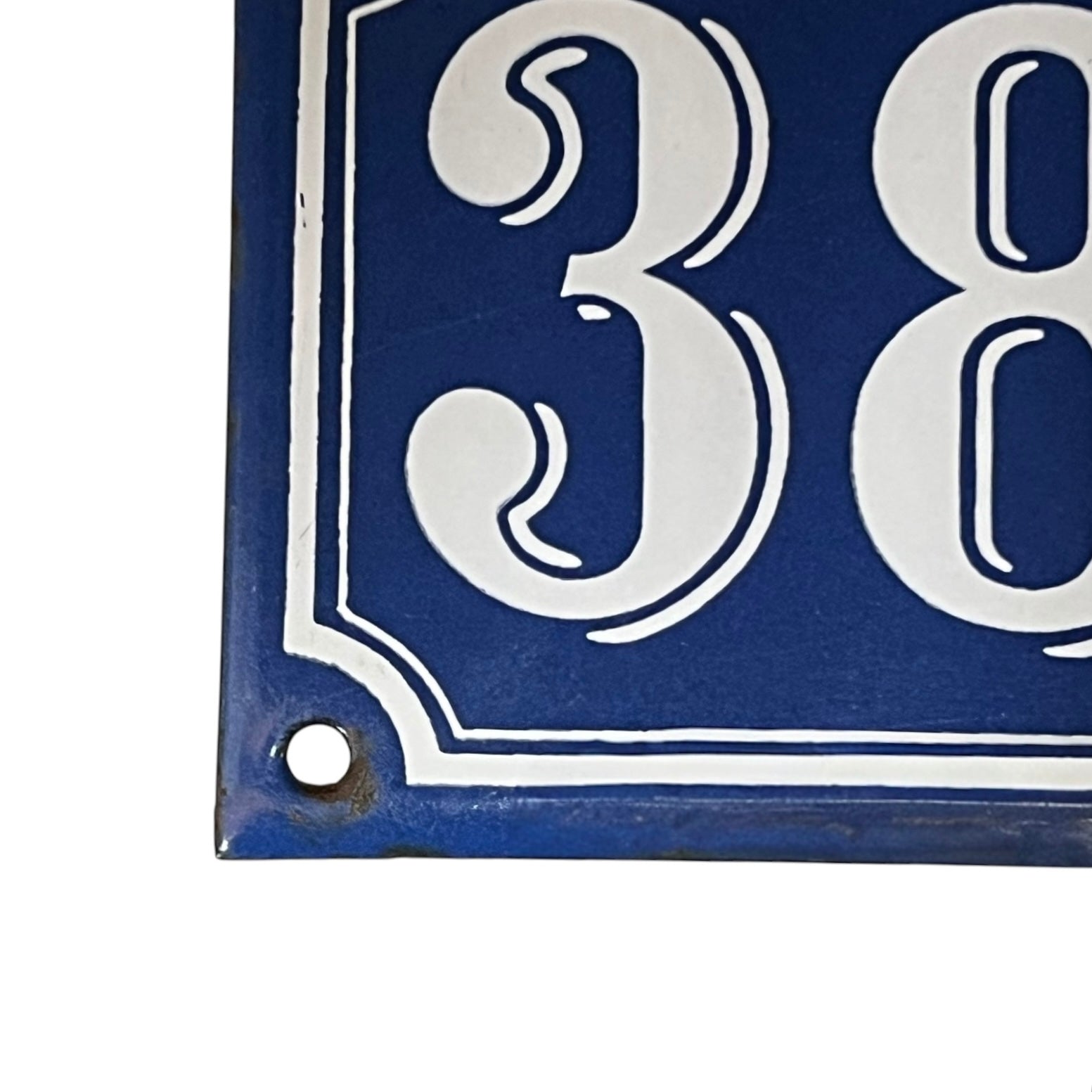Blue and white house number '384' sign on a white background