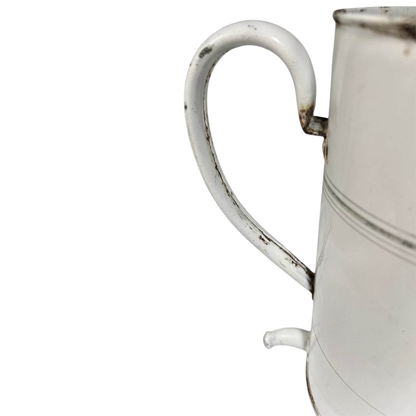 A close-up of a white enamel metal pitcher with a curved handle and a small spout, showing distressed dark paint details on a white background.