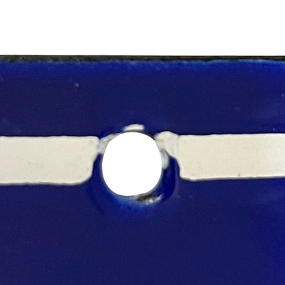 Close-up of a glossy dark blue object with a central circular cutout and a horizontal white strip running through the middle.