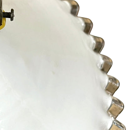Close-up of a white glass lampshade with decorative edge on a white background