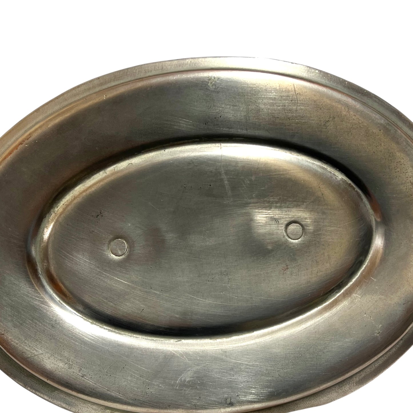 Close up of the inside of a French copper pan with tin lining on a white background