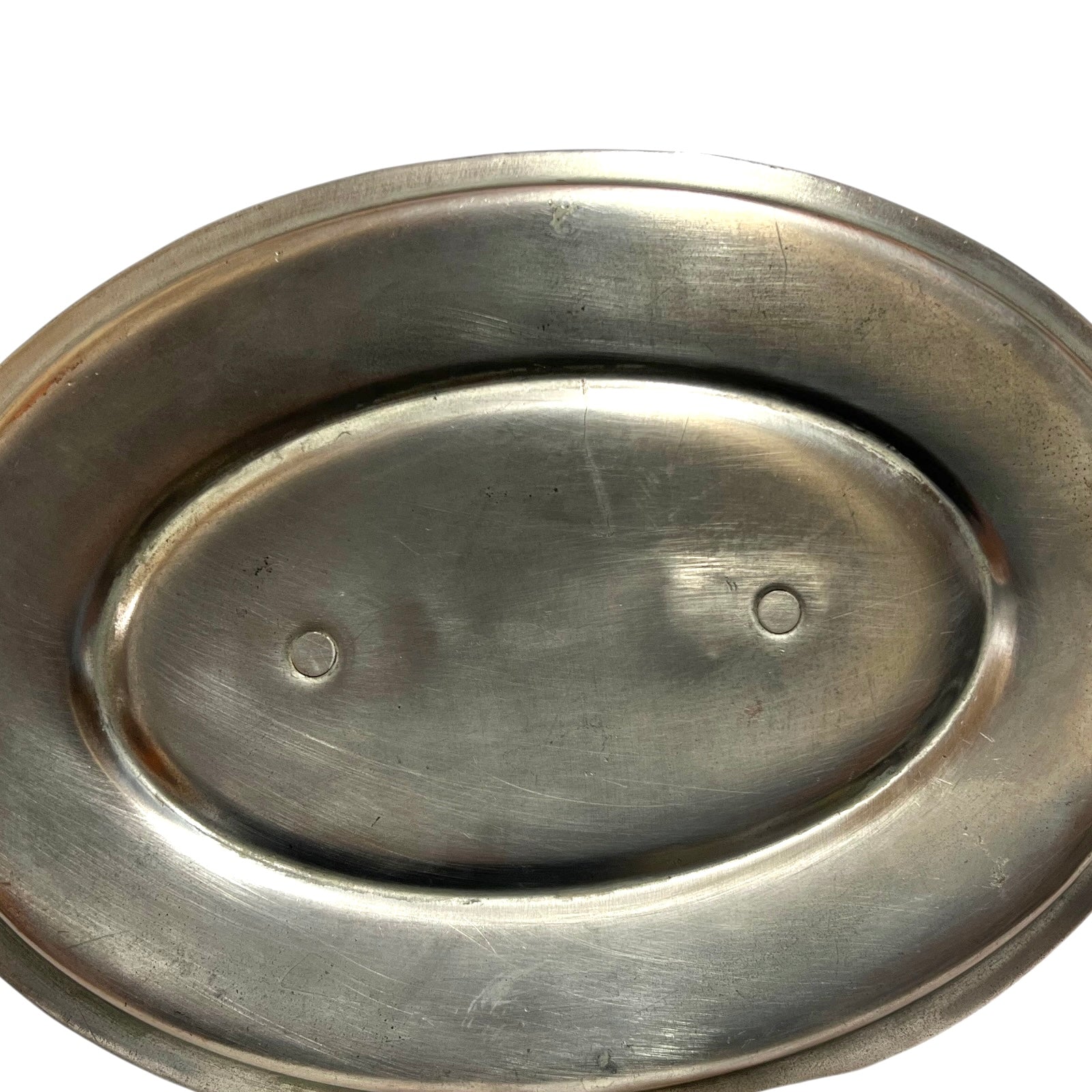 Close up of the inside of a French copper pan with tin lining on a white background