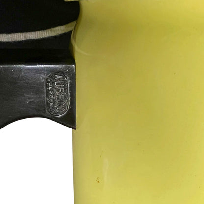 Close-up of a yellow insulated container or bottle next to a black handle with an embossed 'AUBRESCU DESPENSE' brand mark.