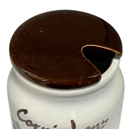 White jar with a dark brown lid on a white background