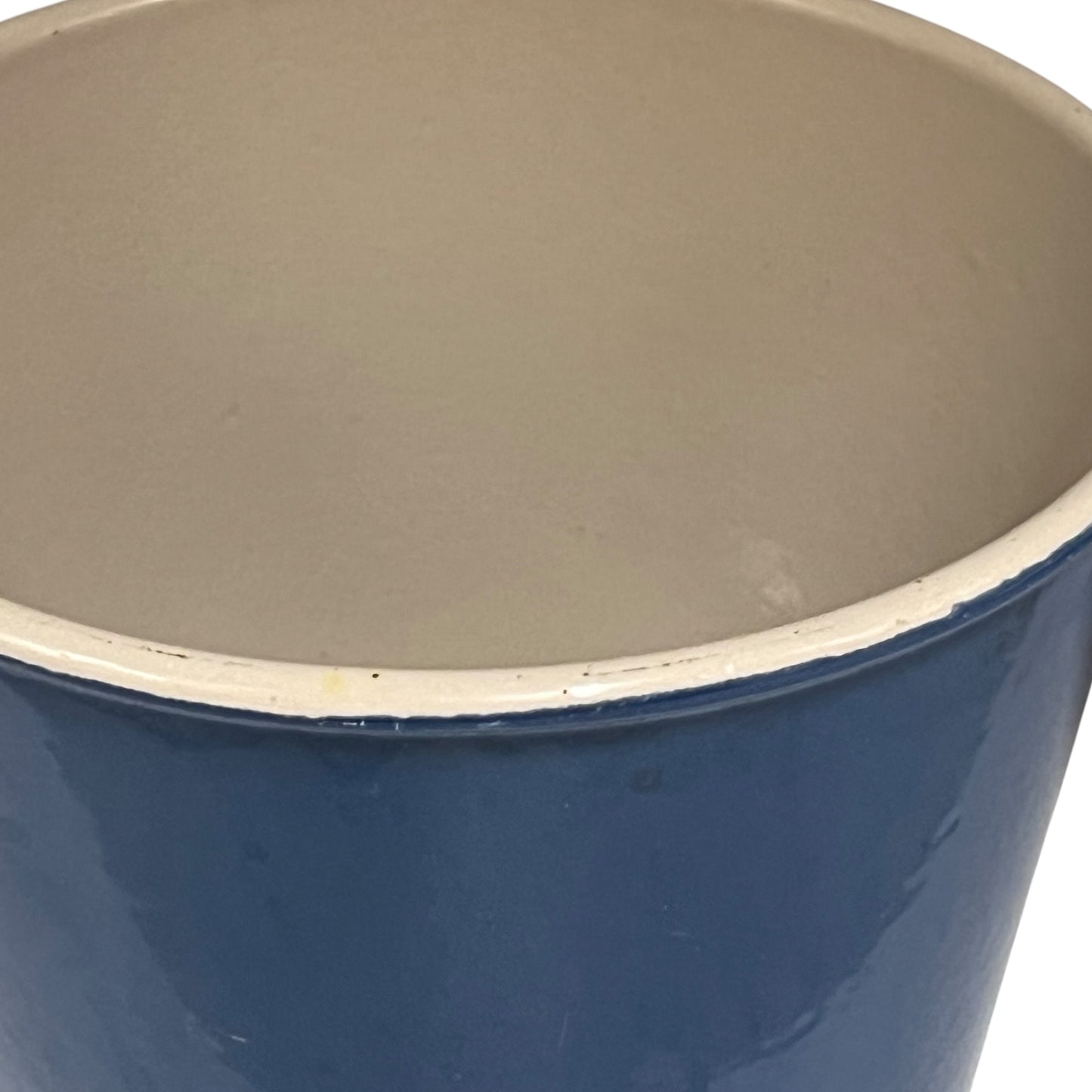 Blue Le Creuset cast iron pan with beige interior on a white background