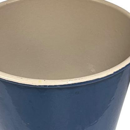 Blue Le Creuset cast iron pan with beige interior on a white background