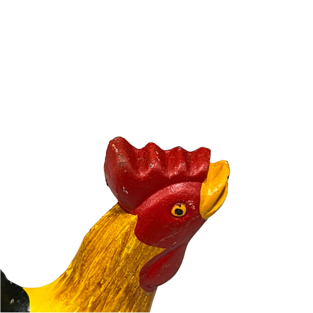 A close-up of a painted rooster figurine showing a red comb and wattle, yellow neck, and yellow beak against a plain white background.