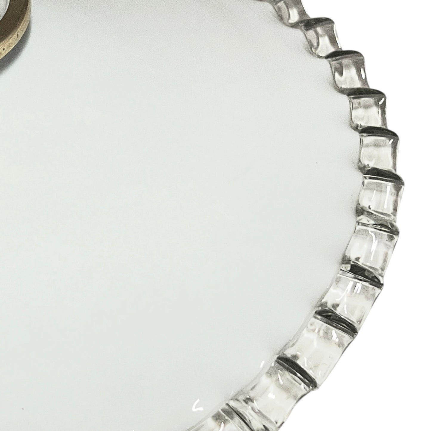 Close-up of a glass lampshade with a decorative edge on a white background