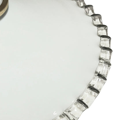 Close-up of a glass lampshade with a decorative edge on a white background