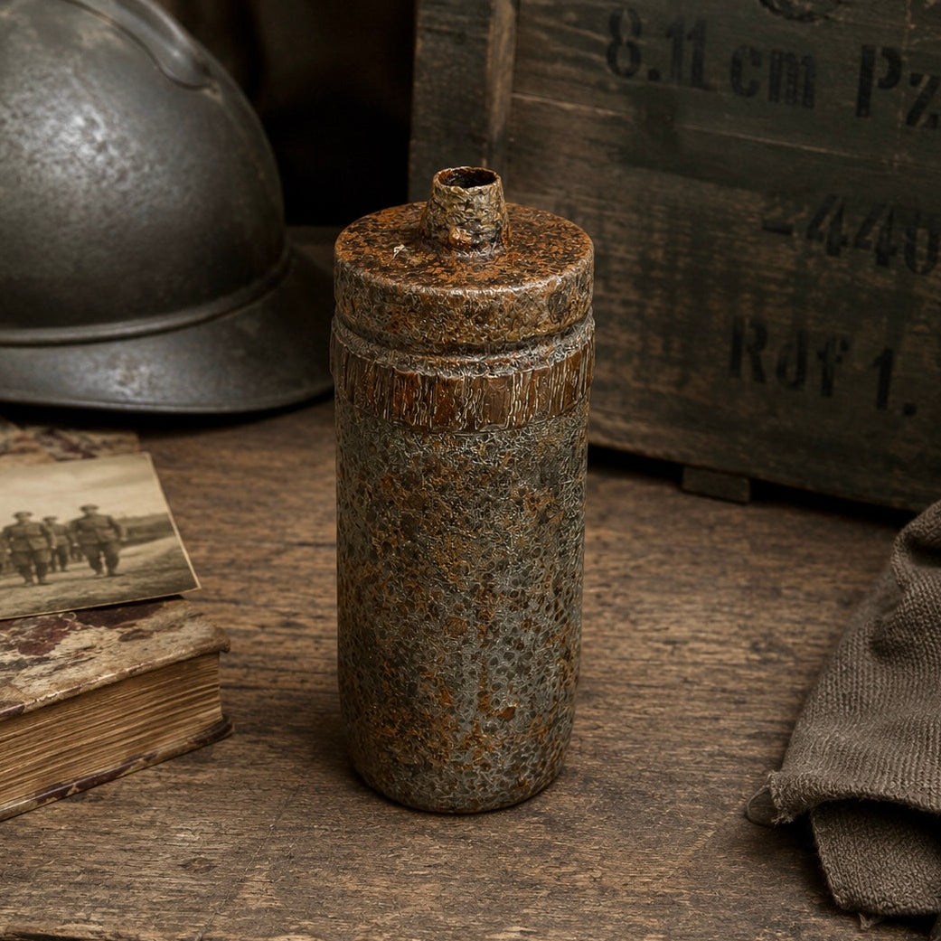 An empty, inert WW1 militaria iron relic from the Battlefields of the Somme, perfect for any collector, set in a bunker style setting beside a helmet and some books