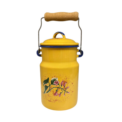A vintage yellow enamel milk canister with a wooden handle, metal wire frame, blue trim, and a floral print on the front, isolated on a white background.