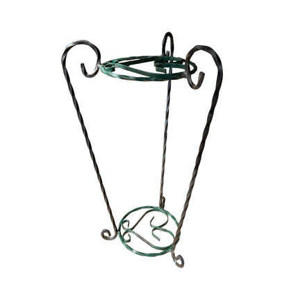 Green and black wrought iron jardinière scrolled plant stand on a white background