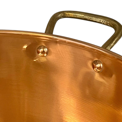Close-up of a copper sink with a brass handle on a white background