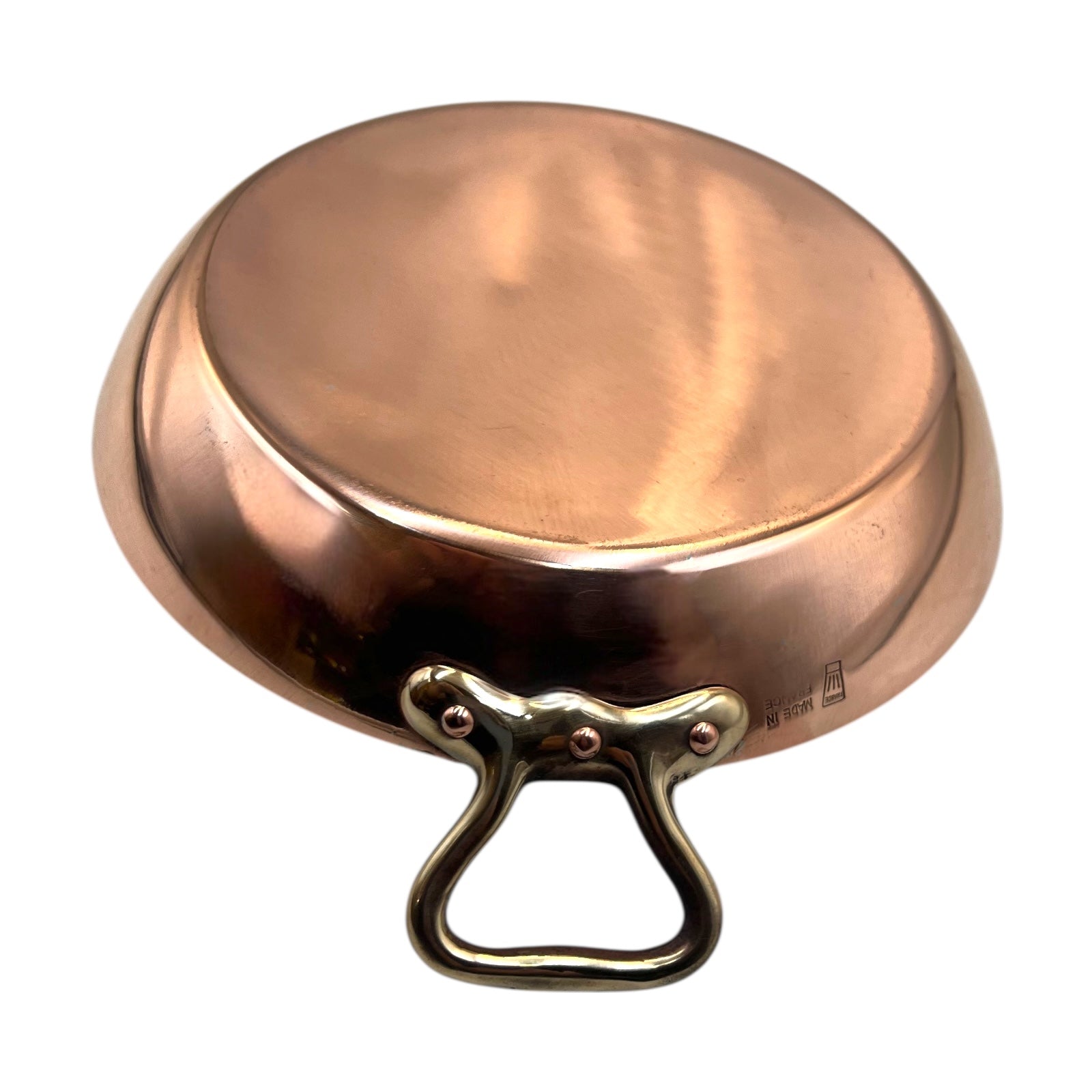 French copper round gratin pan with brass handles on a white background