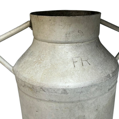 Close up of a vintage metal milk churn on a white background