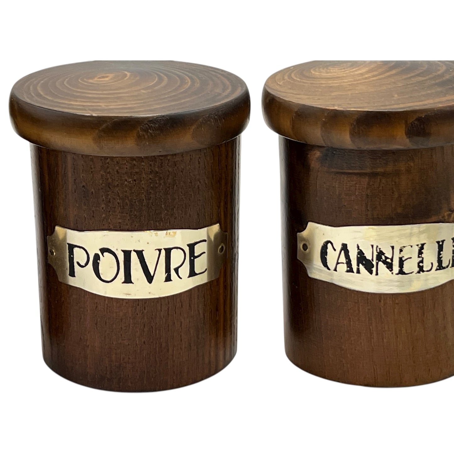Two wooden jars with labels 'Poivre' and 'Cannelle' on a white background