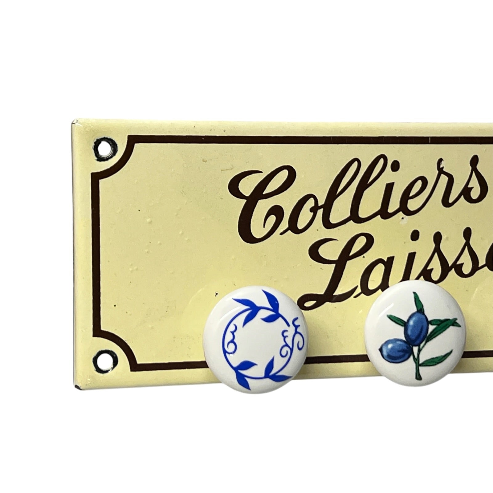 A cream-colored decorative sign with black script reading 'Colliers Laisses